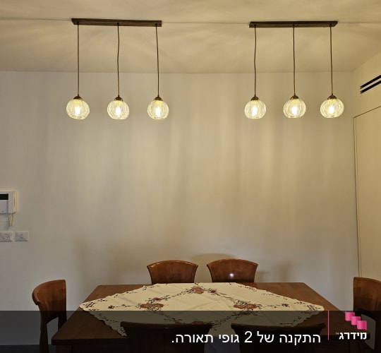 חדר אוכל עם מנורות תלויות ושולחן עץ